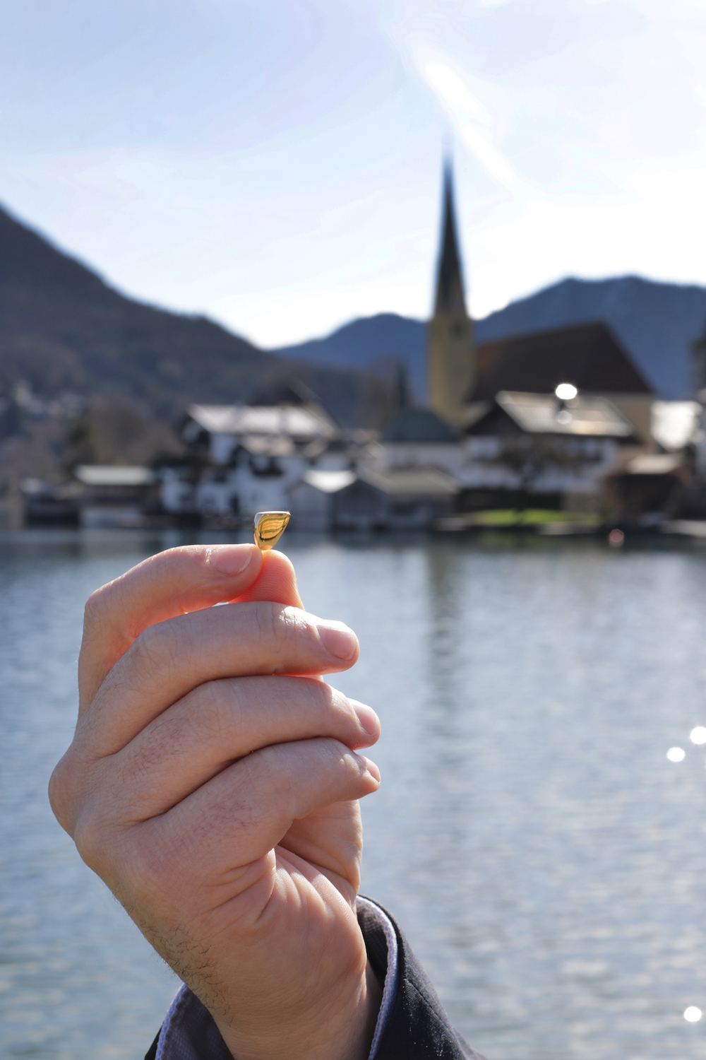 Hannes Gamper hält einen Stein am Tegernsee ins Sonnenlicht